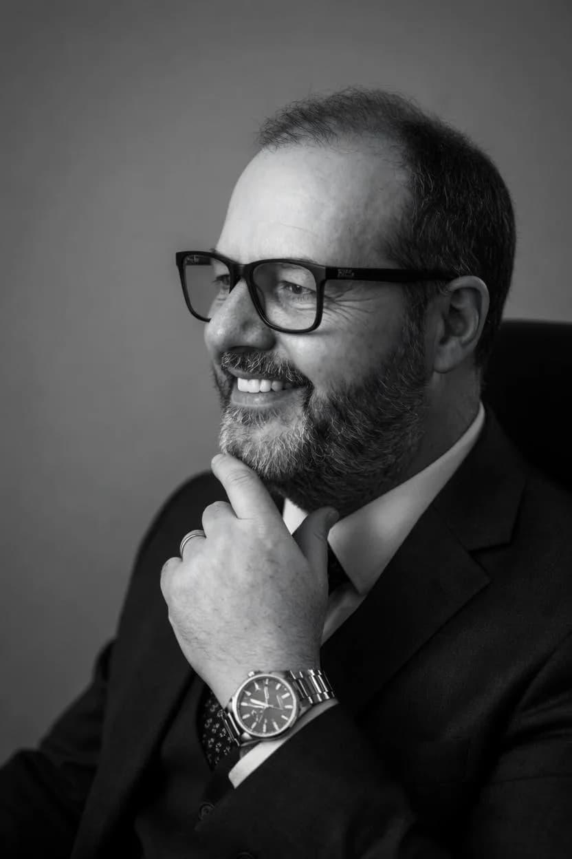 O mesmo retrato em preto e branco: advogado de óculos com a mão no queixo